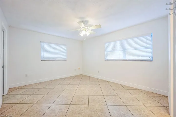 Empty room featuring ceiling fan and light tile patterned flooring