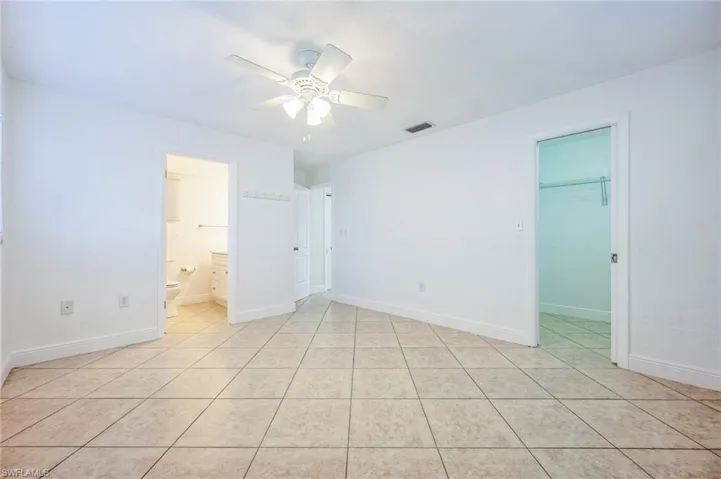 Tiled empty room with ceiling fan