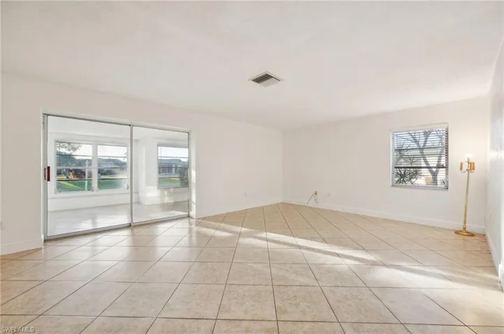 Tiled empty room featuring a wealth of natural light