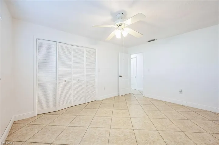 Unfurnished bedroom featuring a closet, ceiling fan, and light tile patterned flooring