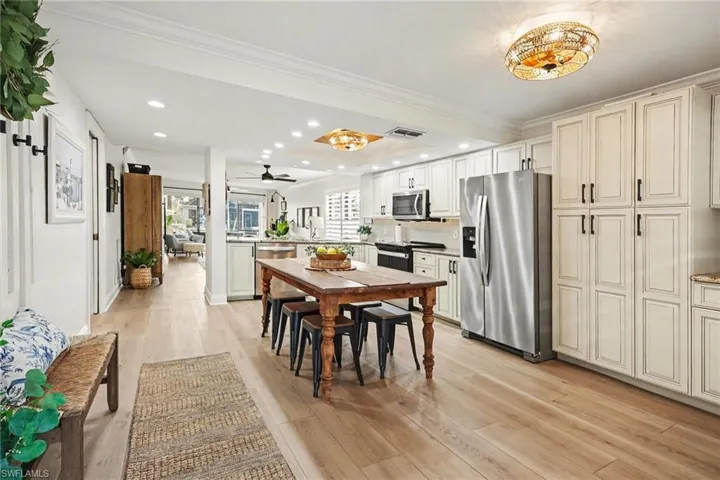 Dining area featuring ornamental molding, light wood finished floors, recessed lighting, and ceiling fan