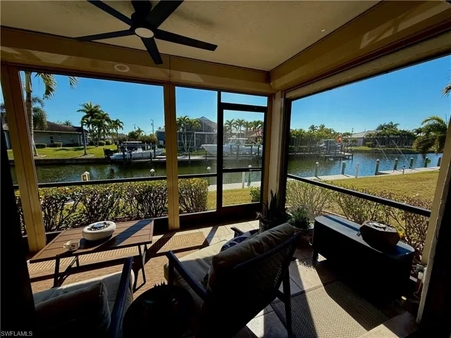 Sunroom with a ceiling fan, a water view, an outdoor living space, and plenty of natural light
