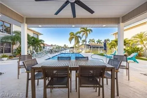 View of patio with ceiling fan, a community pool, and outdoor dining space