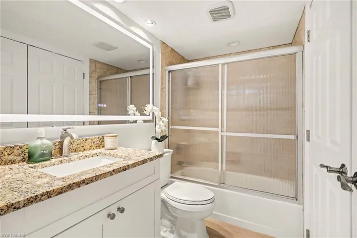 Full bathroom featuring shower / bath combination with glass door and vanity