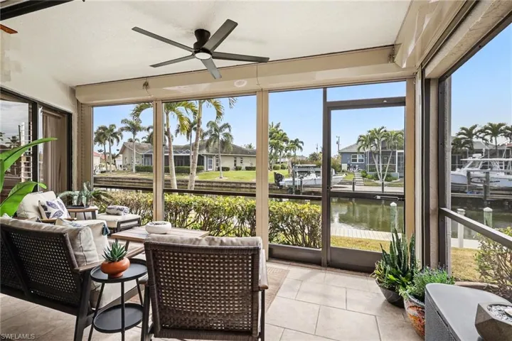 Sunroom / solarium with a water view, healthy amount of natural light, and tile patterned floors