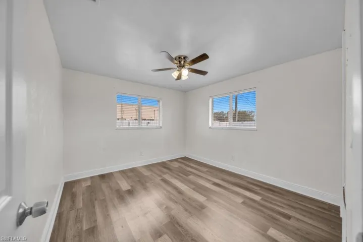 Unfurnished room featuring light wood-style flooring, plenty of natural light, and ceiling fan