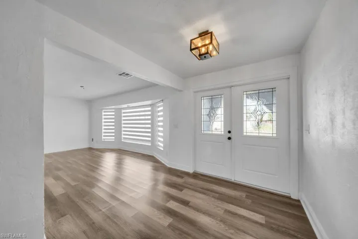 Entrance foyer featuring wood finished floors, french doors, and a textured wall