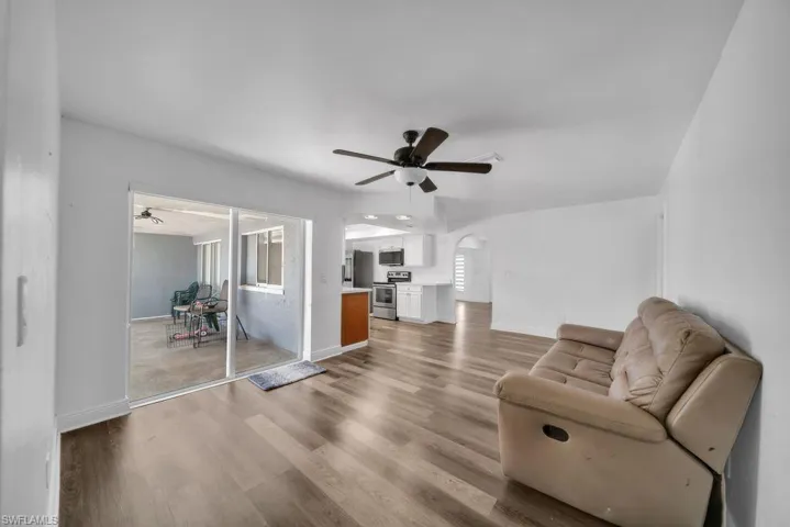 Sitting room featuring a ceiling fan, arched walkways, and wood finished floors