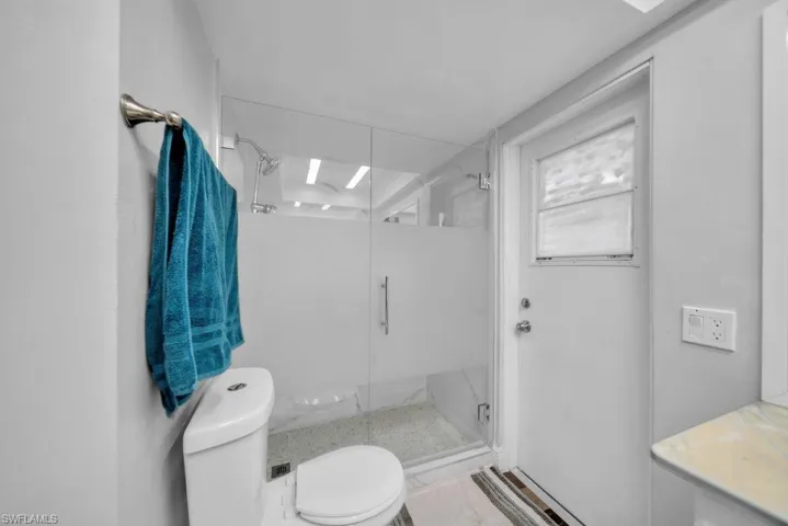 Bathroom with a marble finish shower and vanity