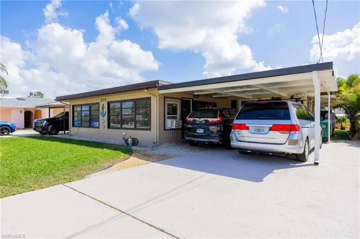 View of car parking with concrete driveway and an attached carport