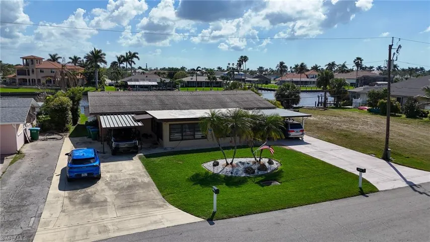 View of front of property featuring a residential view, driveway, and a front lawn