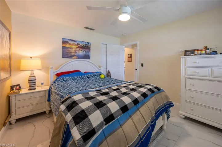 Bedroom with marble finish floor, ceiling fan, and visible vents
