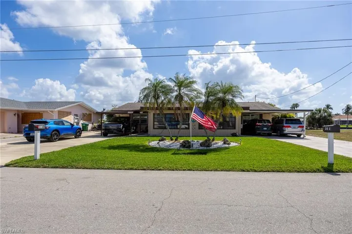 View of front of home with a front yard and concrete driveway
