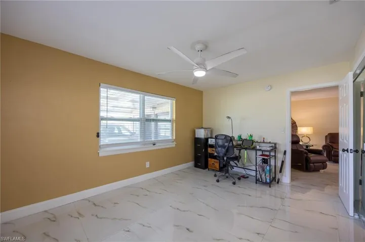 Office space featuring marble finish floor, baseboards, and a ceiling fan