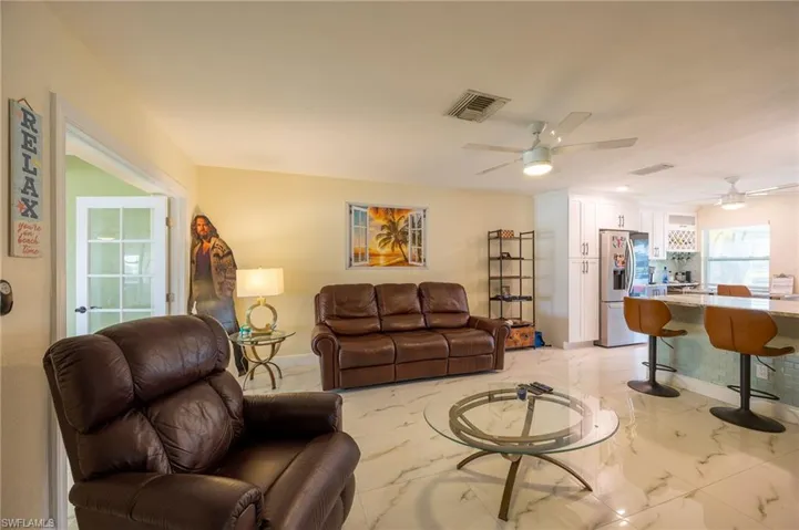 Living area with marble finish floor, ceiling fan, and visible vents
