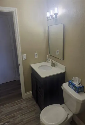 Bathroom featuring a contemporary vanity with an integrated sink, a white countertop, and a dark wood-finish cabinet