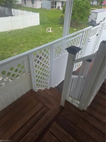 Wood-finish stairs and landing with white lattice railing