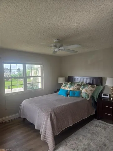 Bedroom featuring wood-finish flooring, a ceiling fan, and a double window