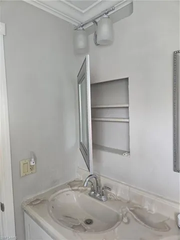 Recessed medicine cabinet with mirrored door, chrome faucet, and integrated sink