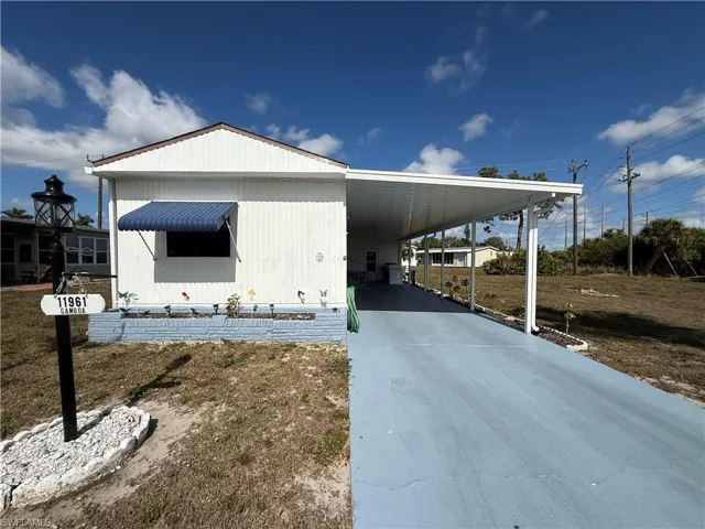 View of side of property featuring driveway and a carport