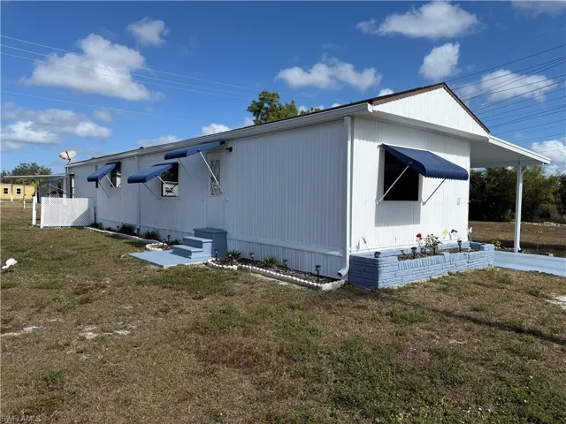 View of side of home with a yard
