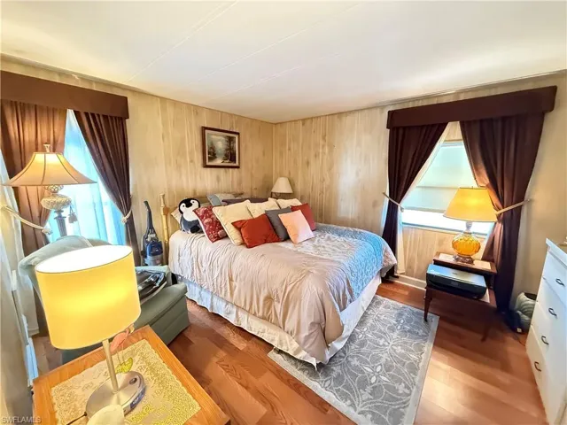 Bedroom featuring wood finished floors and wooden walls
