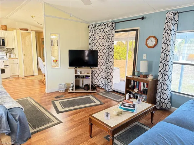 Living room with light wood-type flooring and vaulted ceiling