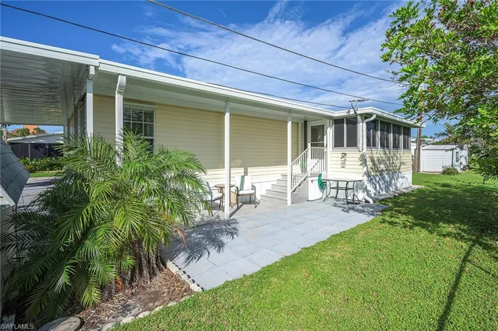 Back of house featuring a carport and a lawn