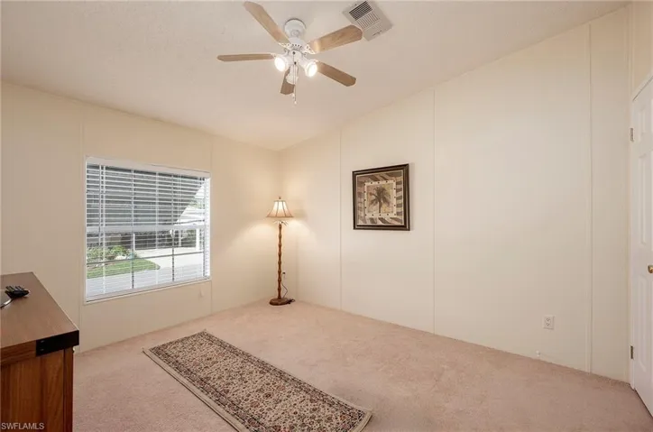 Carpeted bedroom with a textured ceiling and ceiling fan