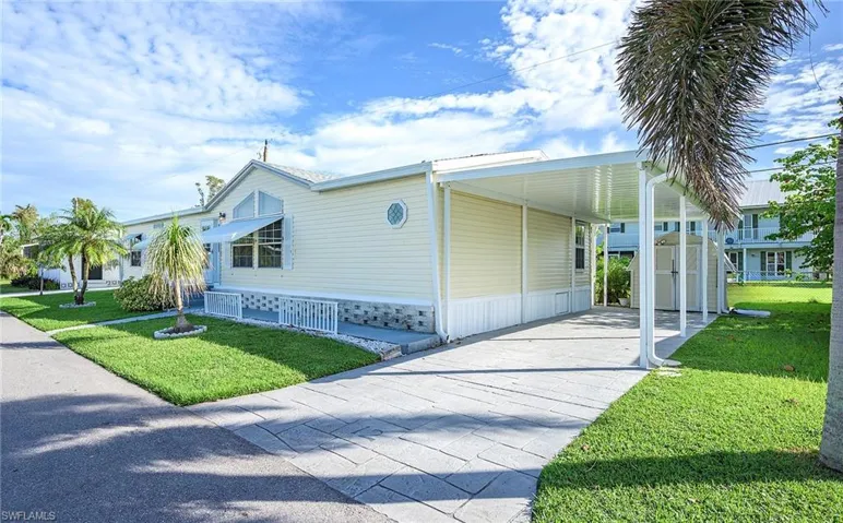 View of side of property with a carport and a yard