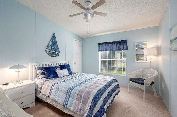 Bedroom with carpet, a textured ceiling, and ceiling fan