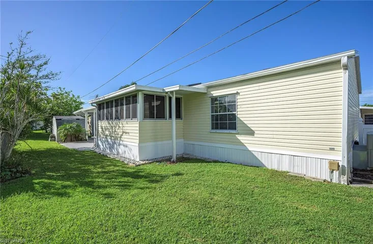 View of side of property featuring a sunroom and a yard