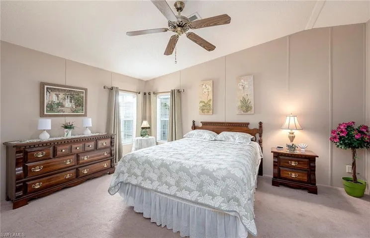 Bedroom featuring a textured ceiling, ceiling fan, light carpet, and vaulted ceiling