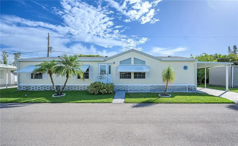 View of front of house featuring a front lawn and a carport