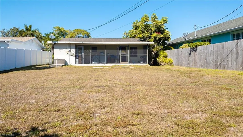 Back of house with a fenced backyard and a sunroom