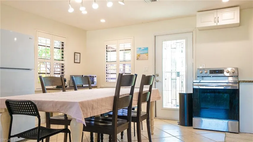 Dining room featuring light tile patterned floors, healthy amount of natural light, and recessed lighting