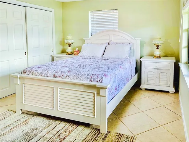 Bedroom with a closet and light tile patterned flooring