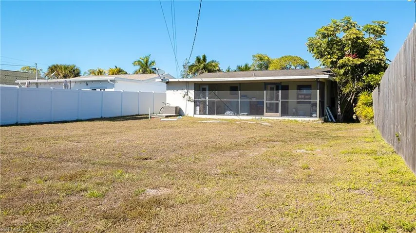 Back of property with a fenced backyard and a sunroom
