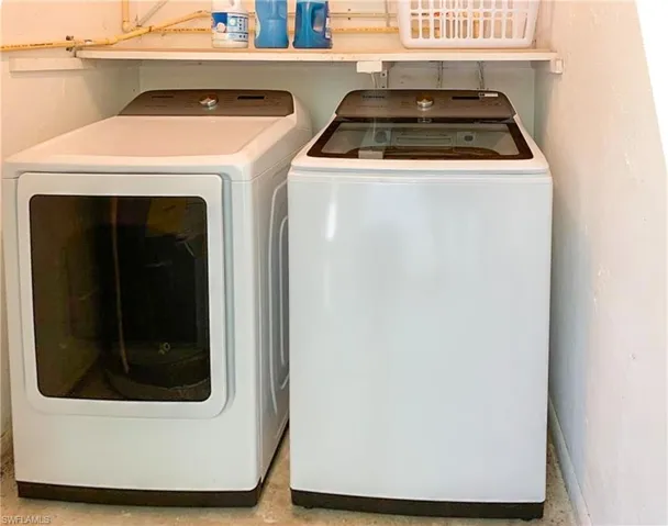 Laundry area with washer and clothes dryer and baseboards