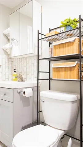 Half bath featuring vanity and decorative backsplash