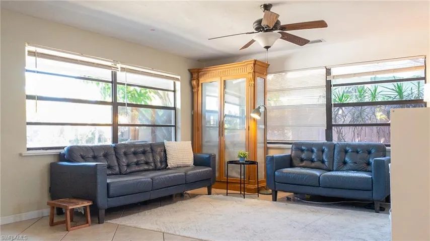 Living area with ceiling fan and tile patterned flooring