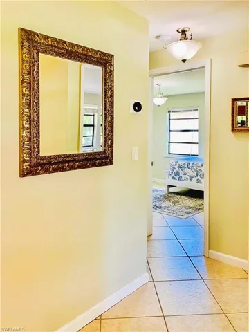 Hall featuring light tile patterned flooring and baseboards