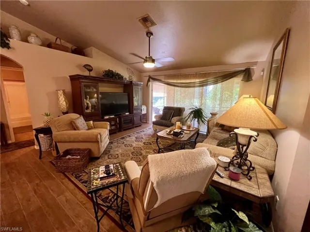 Living room featuring vaulted ceiling, ceiling fan, and hardwood / wood-style floors