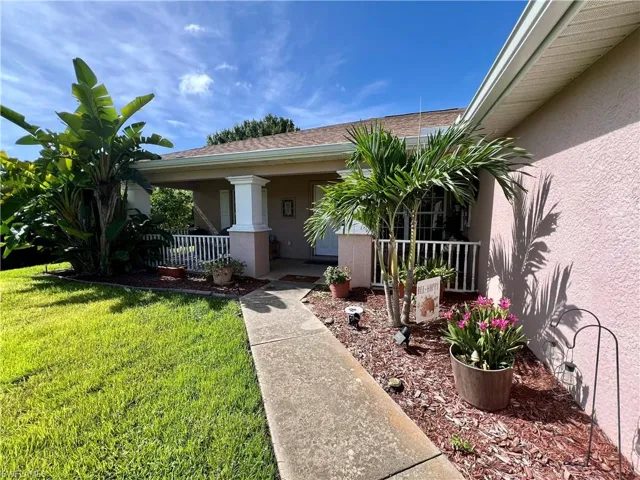 Doorway to property with a lawn
