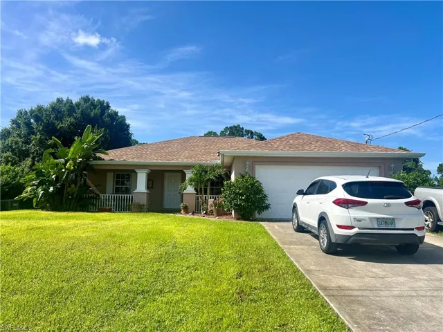 Ranch-style house featuring a garage and a front yard