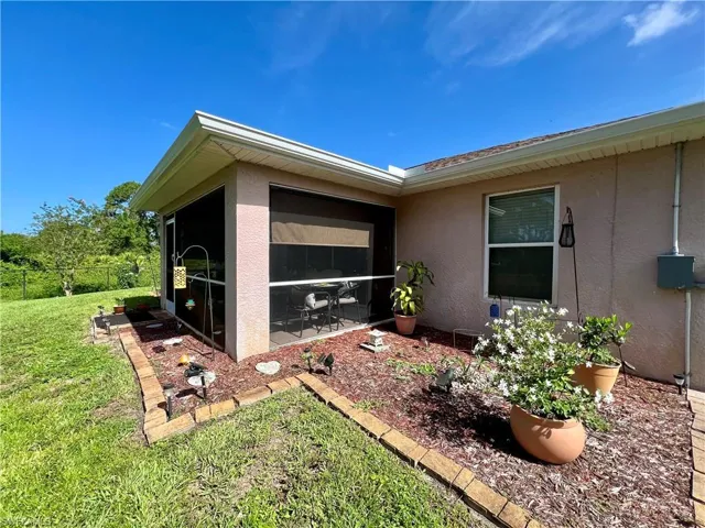 View of home's exterior with a sunroom and a yard