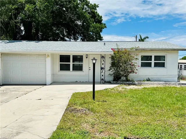 Ranch-style house with a front lawn and a garage