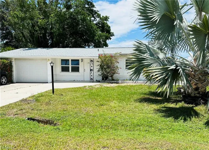 View of front of house featuring a front lawn and a garage