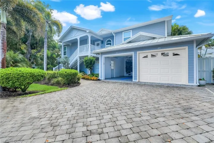 View of front facade with decorative driveway, stairway, and a garage