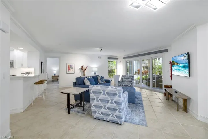 Living area with crown molding and light tile patterned floors